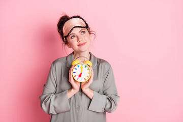 Poster - Photo of pretty positive girl arms hold clock look interested empty space isolated on pink color background