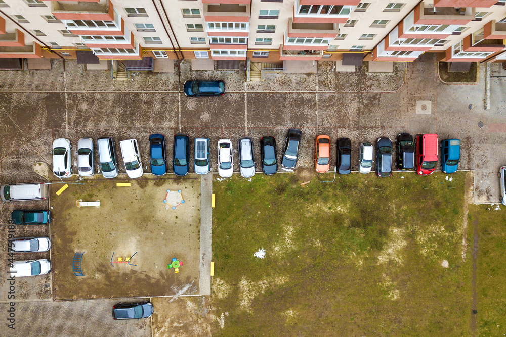 Aerial view of parked cars on parking lot between high apartment ...
