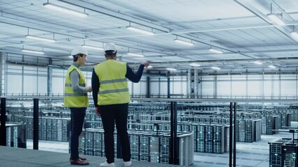 Leinwandbilder - Data Center System Administrators and African American IT Specialists in High Visibility Vests Talk, Use Laptop. IT Engineers work on Cyber Security Network Protection in Server Farm.