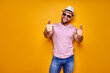 © zamuruev - Young handsome man wearing casual t-shirt standing over isolated yellow background pointing with finger to the camera and to you, hand sign, positive and confident gesture