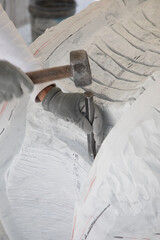 Fototapete - Detail of artist's hands sculpting marble with hammer and chisel