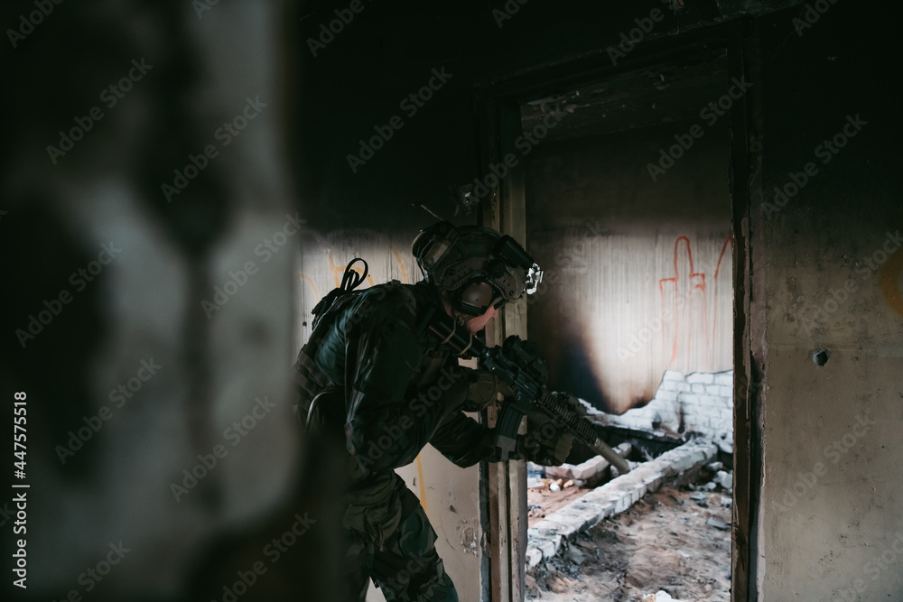 Foto de Stock Military man with assault rifle standing inside building ...