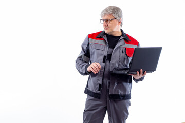Poster - Male computer technician in work uniform. computer technician on a light background. He is holding a laptop in his hands. Concept is work of computer technician. System administrator career
