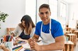 © Krakenimages.com - Two students smiling happy painting sitting on the table at art school.