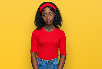 Beautiful african young woman wearing casual clothes relaxed with serious expression on face. simple and natural looking at the camera.