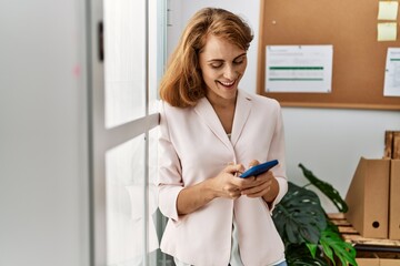 Canvas Print - Young caucasian businesswoman using smartphone at the office.