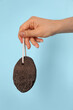 © New Africa - Woman holding pumice stone on light blue background, closeup