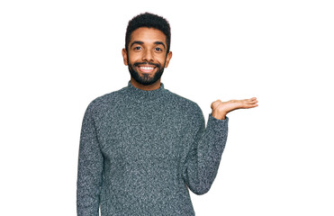 Sticker - Young african american man wearing casual clothes smiling cheerful presenting and pointing with palm of hand looking at the camera.