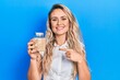 © Krakenimages.com - Beautiful young blonde woman holding jar with rice smiling happy pointing with hand and finger