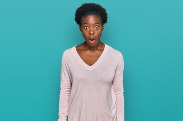 Canvas Print - Young african american girl wearing casual clothes afraid and shocked with surprise and amazed expression, fear and excited face.