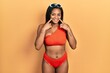 © Krakenimages.com - Young african american girl wearing bikini smiling with open mouth, fingers pointing and forcing cheerful smile