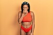 © Krakenimages.com - Young african american girl wearing bikini smelling something stinky and disgusting, intolerable smell, holding breath with fingers on nose. bad smell