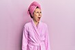 © Krakenimages.com - Young blonde woman wearing shower towel cap and bathrobe angry and mad screaming frustrated and furious, shouting with anger. rage and aggressive concept.
