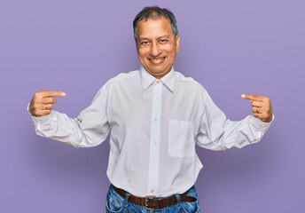 Poster - Middle age indian man wearing casual white shirt looking confident with smile on face, pointing oneself with fingers proud and happy.