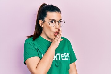 Canvas Print - Young hispanic woman wearing volunteer t shirt hand on mouth telling secret rumor, whispering malicious talk conversation