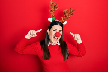 Poster - Young hispanic woman wearing deer christmas hat and red nose smiling pointing to head with both hands finger, great idea or thought, good memory