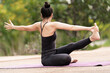 © EduLife Photos - A confident middle-aged Asian woman in a sports outfit doing yoga exercise on the yoga mat outdoor in the backyard in the morning. Young woman doing yoga exercise outdoor in nature public park