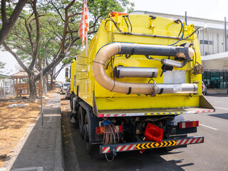 car for cleaning roads with round brushes on a city street.