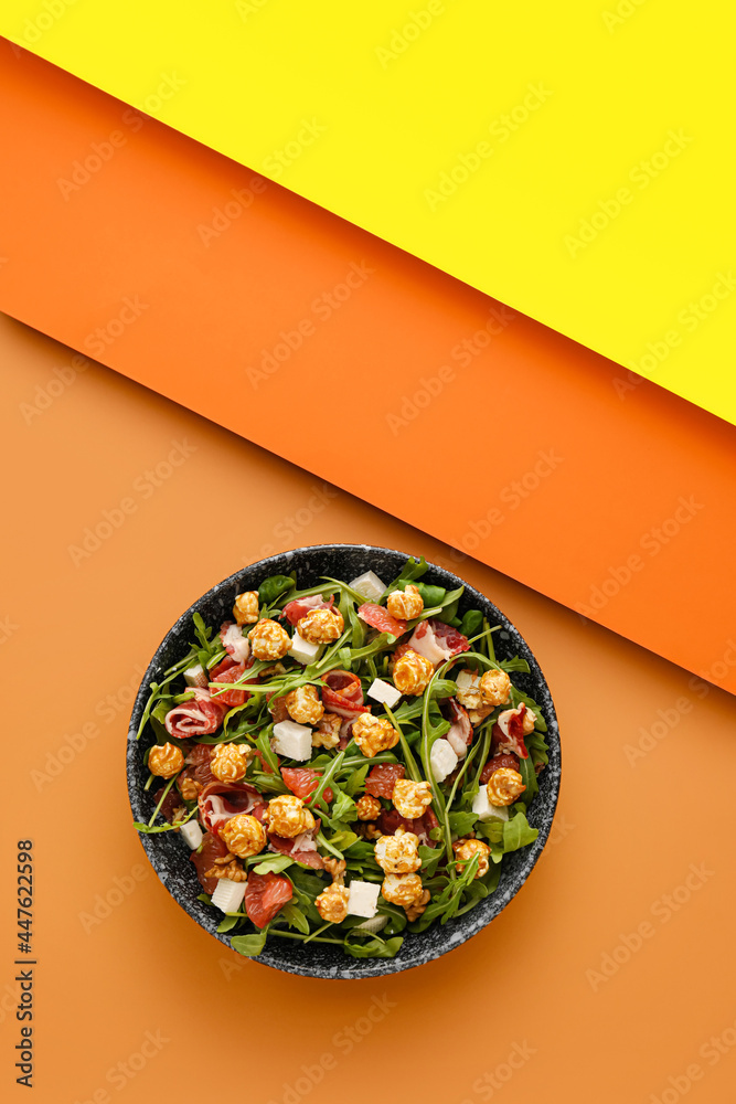 Plate with tasty popcorn salad on color background