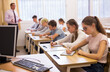 © JackF - Smart teenagers studying in classroom, listening to lecturer and writing in notebooks