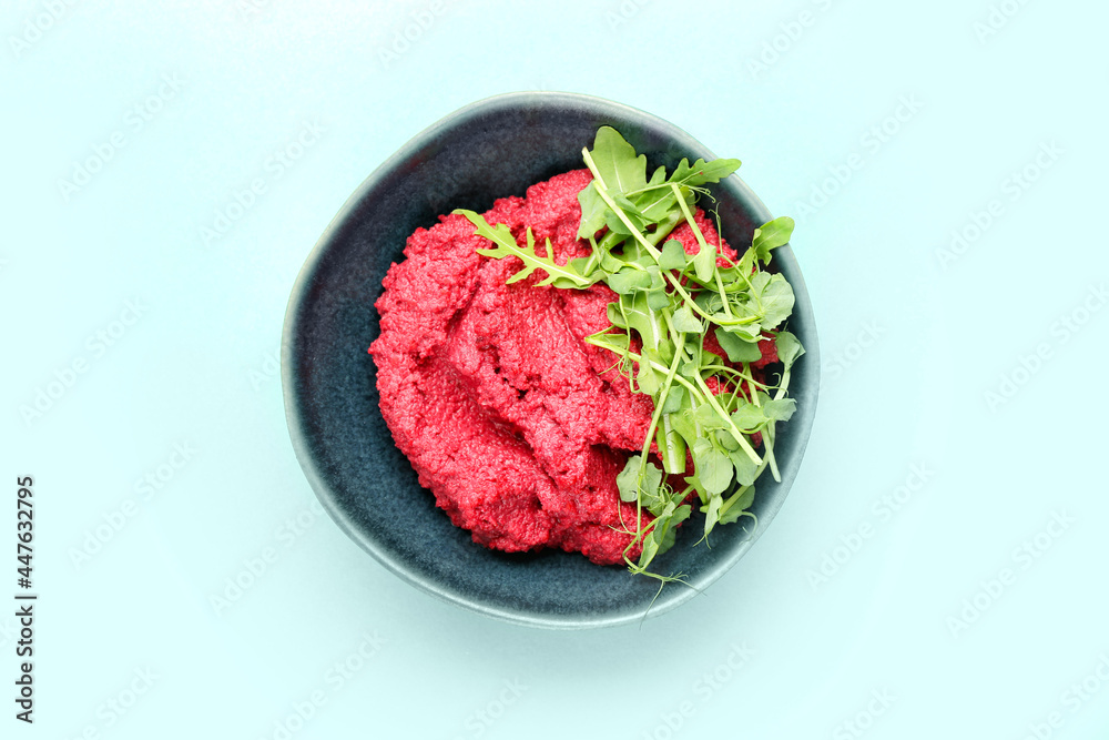 Bowl with tasty beet hummus and fresh sprouts on color background