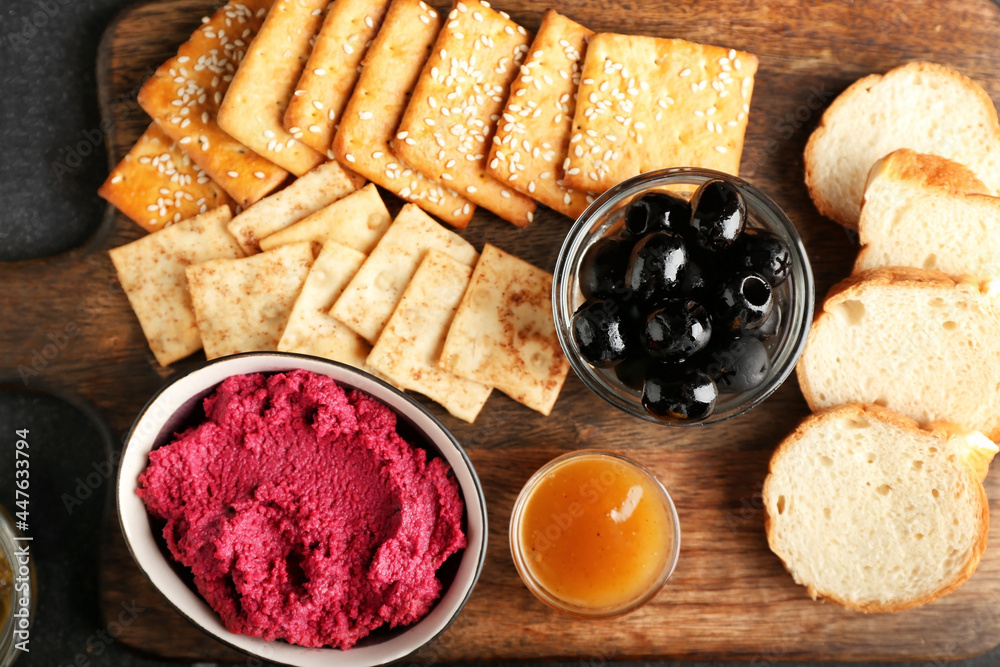 Composition with tasty beet hummus, snacks and sauce, closeup