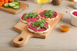 Rice crackers with tasty beet hummus and fresh sprouts on grey wooden background