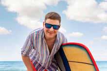 Portrait Of Young Adult Stylish Caucasian Man Wear Casual Shirt And Sunglasses Enjoy Having Leisure Time Surfing At Ocean Seaside Travel Vacation Tropical Resort. Male Surfer Person Surfboard Coast
