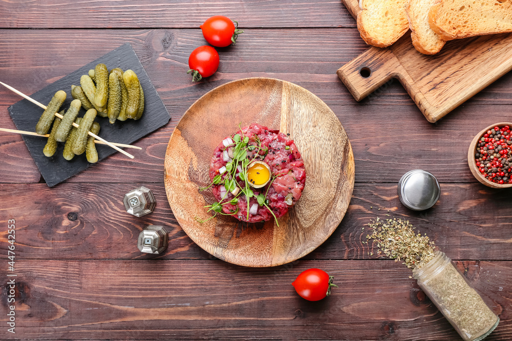 Composition with tasty beef tartare on wooden background