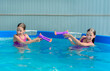 Two tween caucasian girls with water guns toy fight game in pool