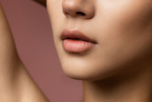 Cropped Image Of Beautiful Female Face, Chin And Neck Isolated On Brown Studio Background.