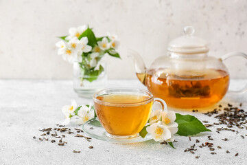 Wall Mural - Composition with cup of jasmine tea and flowers on light background