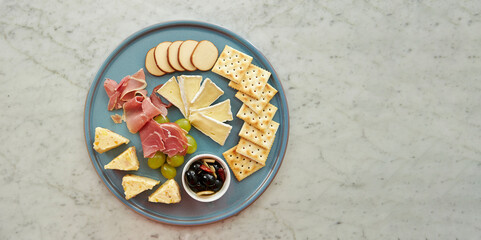 Wall Mural - Set of crackers, ham, cheese and olives on a plate