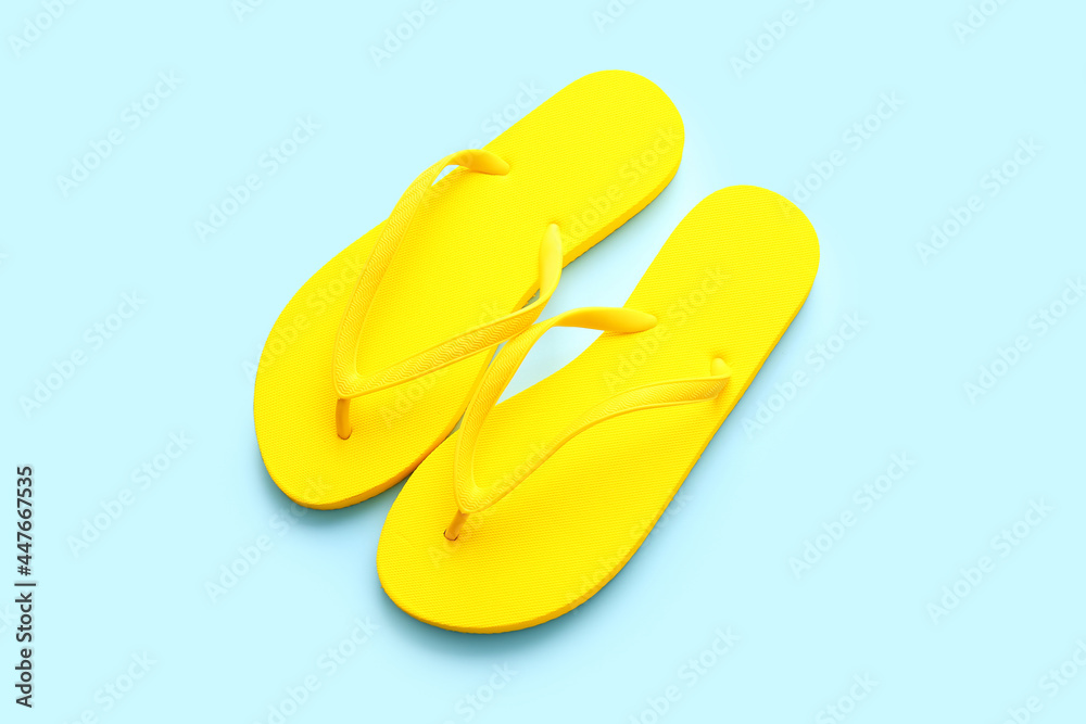 Stylish flip-flops on color background