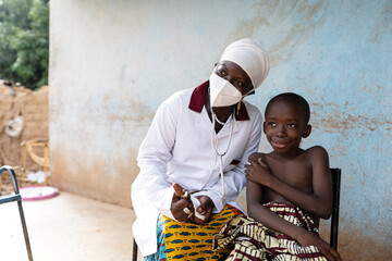 young african pediatrician wearing a protective mask with her smiling little patient just after vacc