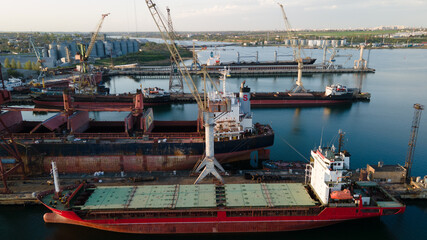 Wall Mural - Industrial port in the field of import-export global business logistics and transportation, Loading and unloading container ships, cargo transportation from a bird's eye view.