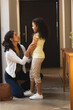 © Wavebreak Media - Happy mixed race mother and daughter talking in hallway