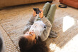 © Wavebreak Media - Mixed race girl lying on carpet using smartphone