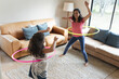 © Wavebreak Media - Happy mixed race mother and daughter playing with hula hoop in living room