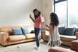 © Wavebreak Media - Happy mixed race mother and daughter dancing in living room