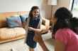 © Wavebreak Media - Happy mixed race mother and daughter dancing in living room