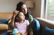 © Wavebreak Media - Mixed race mother and daughter sitting on sofa, embracing and looking through window