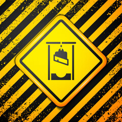 Poster - Black Guillotine medieval execution icon isolated on yellow background. Warning sign. Vector