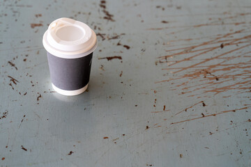 Poster - Closeup shot of a paper cup with coffee on a grunge surface