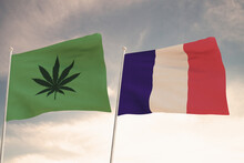 Interesting Flags Of FRANCE  And That Of The Legalization Of Marijuana Waving With The Bright Sky In The Background.