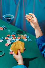 Crop Rich Woman With Cards Playing Poker