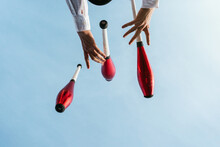 Juggler Performing Circus Trick Against Blue Sky