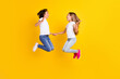 © deagreez - Full length body size view of two nice cheerful ecstatic kids jumping having fun rejoicing isolated over bright yellow color background