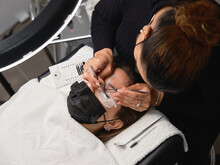 Cosmetologist Doing Eyelash Extension Procedure In Beauty Center