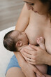 © ADDICTIVE STOCK - Anonymous mother breastfeeding baby in room at home